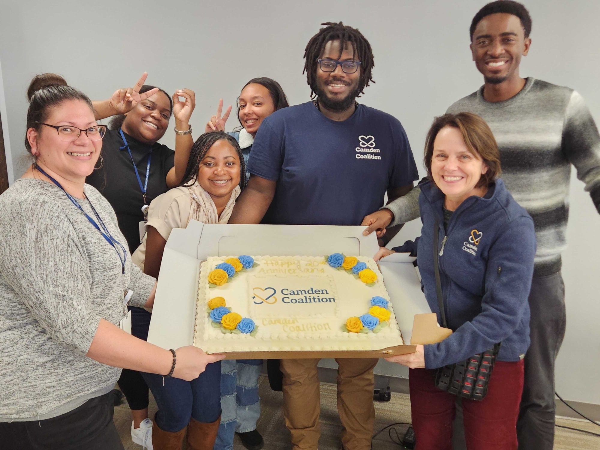 Camden Coalition staff members holding a cake that says "Happy 20th anniversary Camden Coalition"