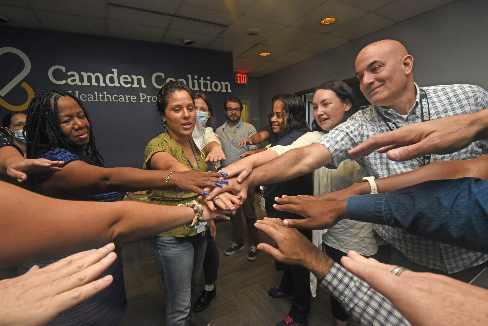 Camden Coalition staff put their hands in the middle for a team huddle