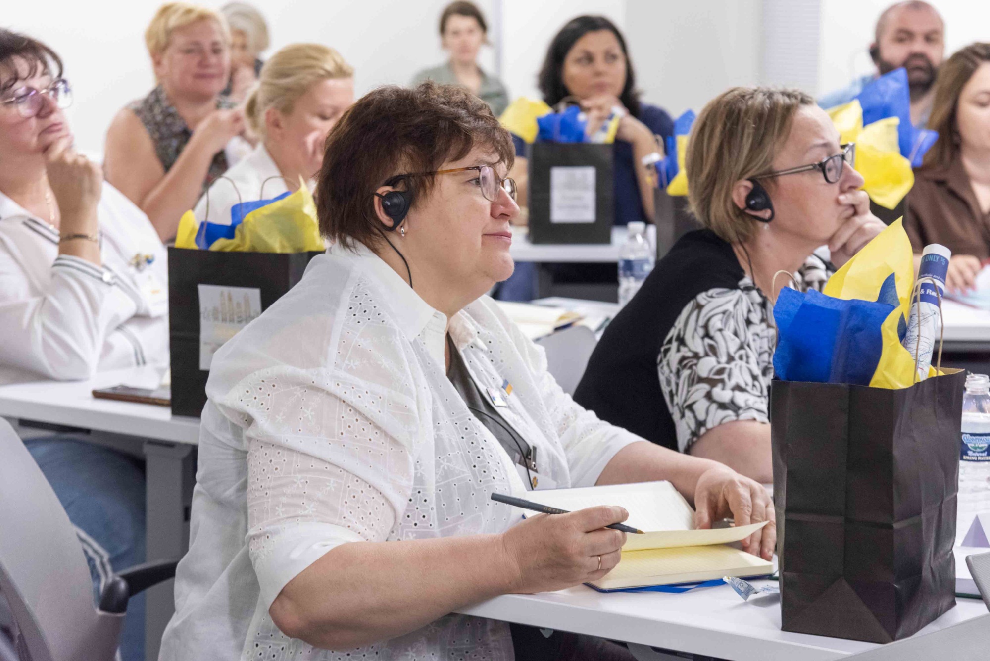 Ukrainian delegates with earpieces for translation watching the presentation